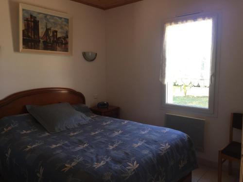 une chambre avec un lit avec une couette bleue et une fenêtre dans l'établissement Maison neuve proche plage avec jardin, 4 couchages, tout confort - FR-1-336-15, à Longeville-sur-Mer