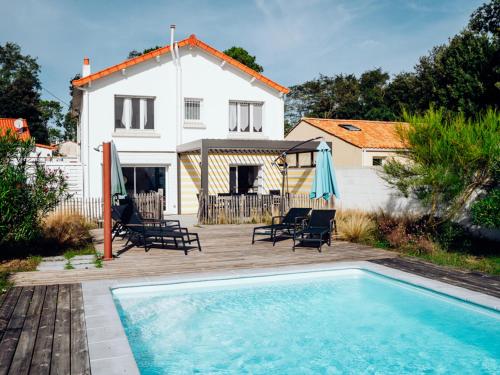une maison avec une piscine devant une maison dans l'établissement Maison indépendante avec jardin, piscine privée chauffée et Wi-Fi, près de la mer à Jard-sur-Mer - FR-1-336-115, à Jard-sur-Mer
