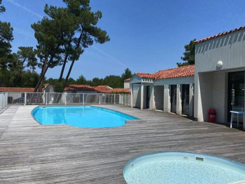 une piscine sur une terrasse à côté d'un bâtiment dans l'établissement Longeville-sur-Mer - Pavillon 4 pers, à 850m de la plage, piscine commune - FR-1-336-108, à Longeville-sur-Mer