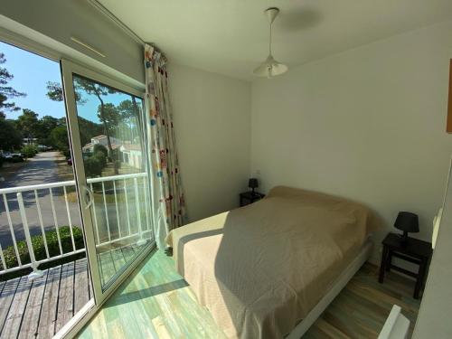 une chambre avec un lit et une grande fenêtre dans l'établissement Longeville-sur-Mer - Pavillon 4 pers, à 850m de la plage, piscine commune - FR-1-336-108, à Longeville-sur-Mer