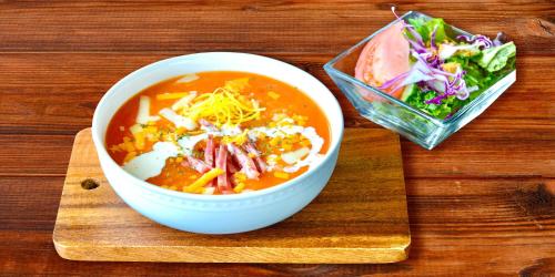 una ciotola di zuppa e un'insalata su un tavolo di legno di Rereso沖縄美ら海 a Motobu