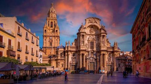 a large building with a clock tower in a city at Tiny house deluxe para escapada con Jacuzzi in Murcia