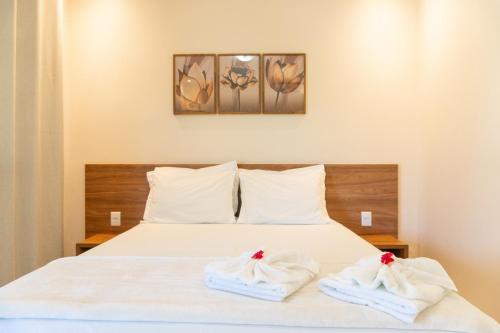 a bedroom with a bed with towels on it at Vila da Mata Chalés in Alto Paraíso de Goiás