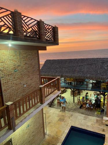 a view of a resort with a pool and the ocean at Chico Caranguejo da Baleia in Itapipoca