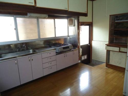 a kitchen with white cabinets and a wooden floor at 峰-Mine in Omachi