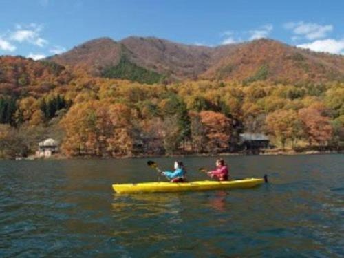 two people in a yellow kayak on a lake at 峰-Mine in Omachi