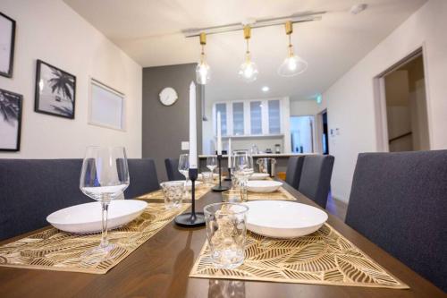 a dining room with a table with wine glasses at Paradiso北谷 in Okinawa City