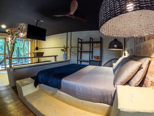 a bedroom with a large bed and a large chandelier at Hotel Casa de Hadas in Minca