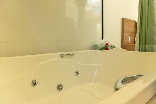 a white bath tub in a bathroom with a mirror at Vila da Mata Chalés in Alto Paraíso de Goiás