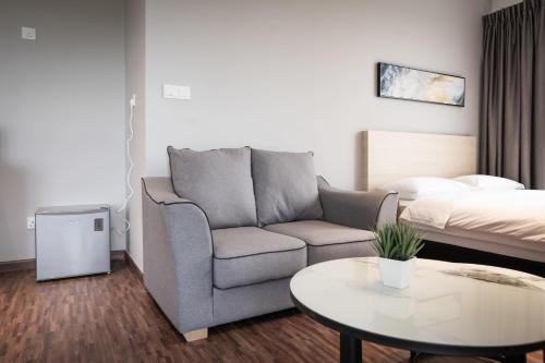 a living room with a couch and a bed at K Avenue by Pinstay in Donggongon