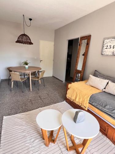 ein Wohnzimmer mit einem Bett und einem Tisch in der Unterkunft Departamento de Josefina in Santiago del Estero