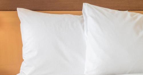 two white pillows on top of a bed at Holiday Inn Singapore Little India by IHG in Singapore