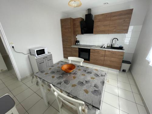 une cuisine avec une table avec un bol dessus dans l'établissement Maison de ville avec jardin, proche plage et commerces, parking privé - La Tranche-sur-Mer - FR-1-22-370, à La Tranche-sur-Mer