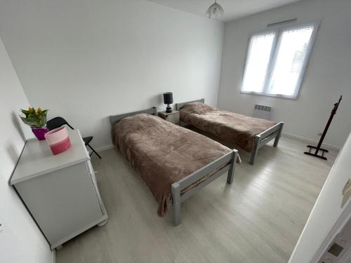 une chambre avec deux lits et une table et une fenêtre dans l'établissement Maison de ville avec jardin, proche plage et commerces, parking privé - La Tranche-sur-Mer - FR-1-22-370, à La Tranche-sur-Mer