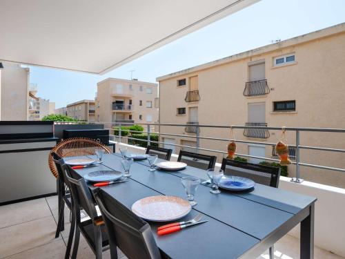 un balcon avec une table bleue et des chaises dans l'établissement T3 climatisé neuf, proche plage avec terrasse spacieuse et parking à Narbonne - FR-1-409-272, à Narbonne