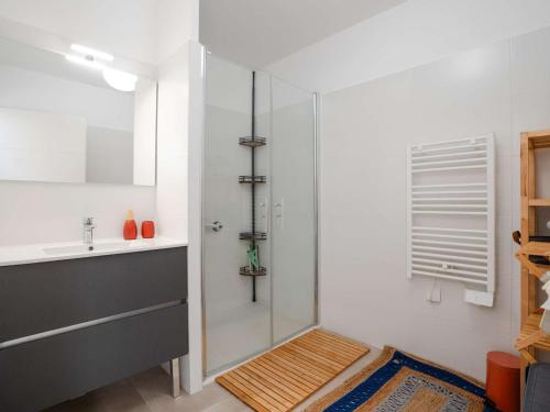 une salle de bain avec une douche en verre et un lavabo dans l'établissement T3 climatisé neuf, proche plage avec terrasse spacieuse et parking à Narbonne - FR-1-409-272, à Narbonne