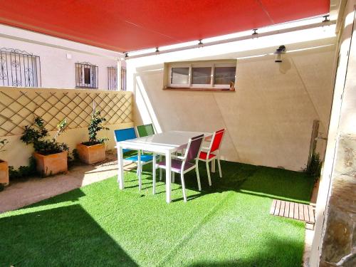 d'une terrasse avec une table et des chaises sur gazon. dans l'établissement Maison à Banyuls: Wifi, jardin, climatisation, à 5 min de la plage, proche centre et commerces - FR-1-309-472, à Banyuls-sur-Mer