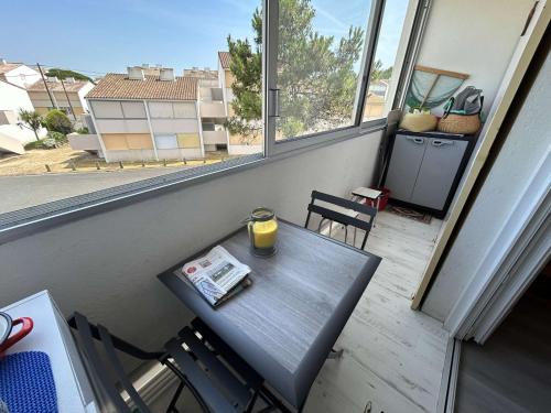 - une table avec un verre de jus d'orange sur un balcon dans l'établissement Appartement rénové 300m plage, balcon, parking privé, 4-5 couchages, Saint-Hilaire-de-Riez - FR-1-224C-316, à Saint-Hilaire-de-Riez