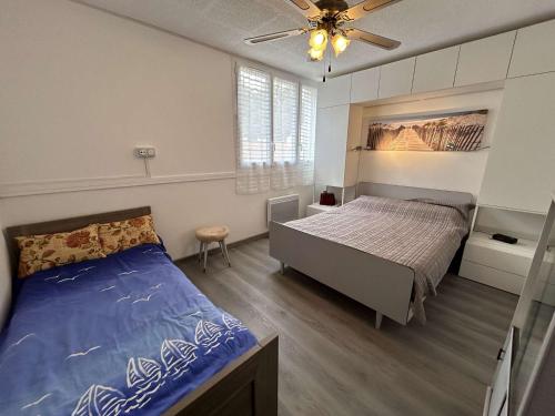 une chambre avec un lit et un ventilateur de plafond dans l'établissement Appartement rénové 300m plage, balcon, parking privé, 4-5 couchages, Saint-Hilaire-de-Riez - FR-1-224C-316, à Saint-Hilaire-de-Riez