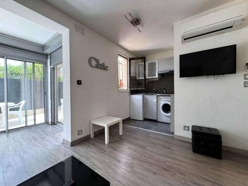 Il comprend un grand salon avec une télévision et une cuisine. dans l'établissement Charmant T2 Climatisé avec Parking Privé, Jardinet, à 900m de la Plage Roquille - FR-1-607-202, au Cap d'Agde