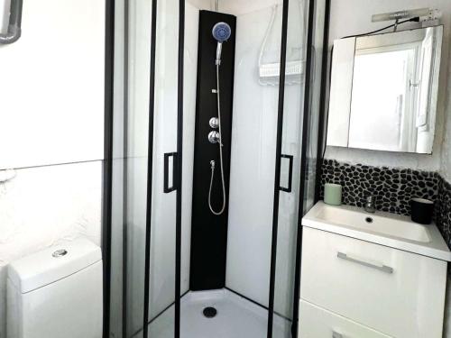 une salle de bain avec douche et lavabo dans l'établissement Charmant T2 Climatisé avec Parking Privé, Jardinet, à 900m de la Plage Roquille - FR-1-607-202, au Cap d'Agde