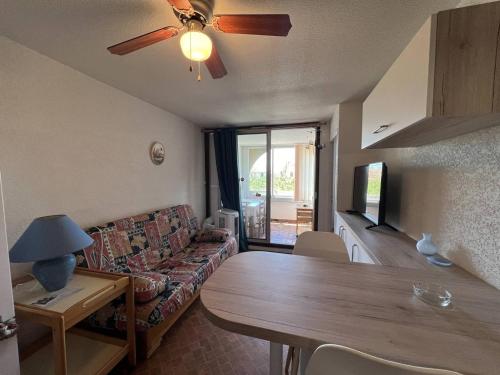un salon avec un canapé et une table dans l'établissement Charmant T2 avec loggia, TV, lave-linge, climatisation portative, proche port et plage à Port Leucate - FR-1-81-621, à Leucate