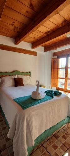 a bedroom with a large bed with a wooden ceiling at Hotel Tierra Maya in San Cristóbal de Las Casas