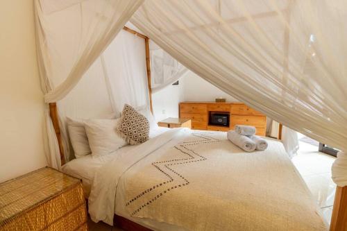 a bedroom with a bed with a teddy bear on it at Boho-chic villa near Cafè Del Mar, 5-minute walk to beach in Canggu
