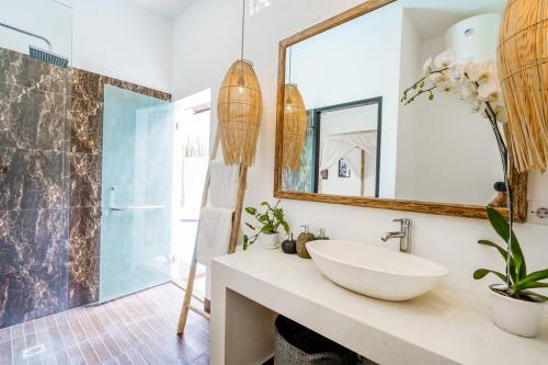 a bathroom with a sink and a mirror at Boho-chic villa near Cafè Del Mar, 5-minute walk to beach in Canggu
