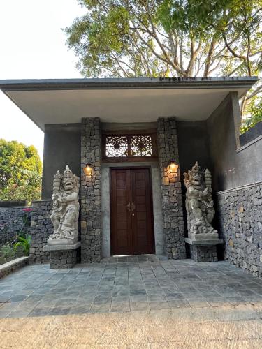a front door of a house with a stone wall at Harvest Palace Munduk in Munduk
