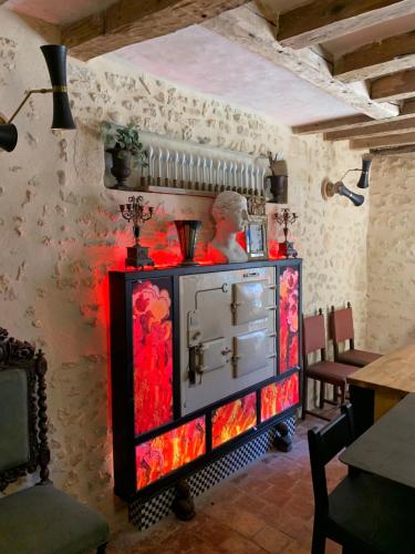 a room with a tv in a room with a wall at AU LIT ON DORT - Logis de Village in Bellême