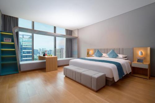 a bedroom with a large bed and a large window at Pagoda Hotel Hangzhou Binjiang in Hangzhou