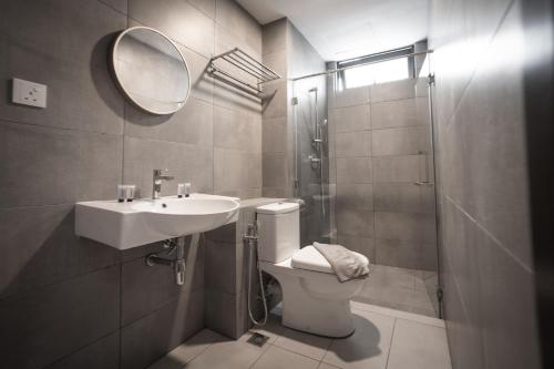 a bathroom with a toilet and a sink and a mirror at K Avenue by Pinstay in Donggongon