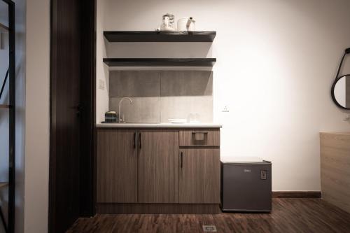 a small kitchen with a sink and a refrigerator at K Avenue by Pinstay in Donggongon