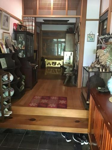 a living room with a wooden floor and a room with a rug at COZY Inn Free Shuttle service in Nikko