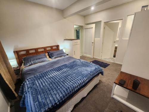 a bedroom with a bed with a blue comforter at Thames River Valley Retreat Residence 1 in Thames