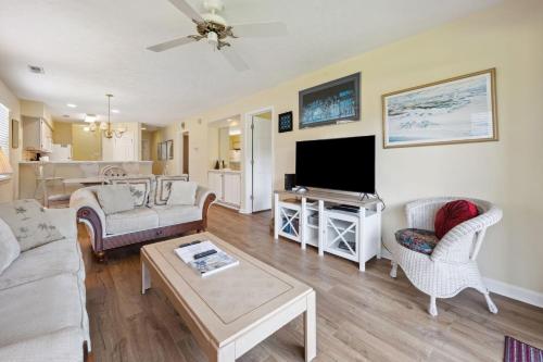 un soggiorno con divano e TV a schermo piatto di 4D Crassostrea II at True Blue Unit condo by Peace Vacations a Pawleys Island