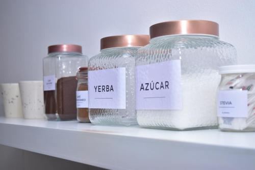 a shelf with several glass jars on it at Apart Moderno Vista al Mar in Comodoro Rivadavia