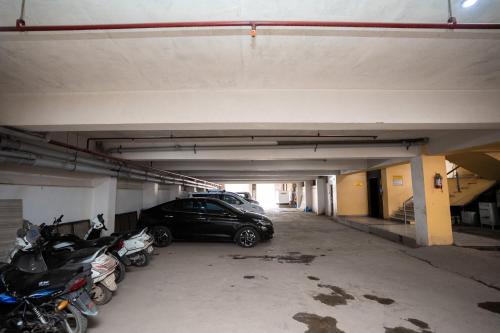 a parking lot with cars and motorcycles parked in it at Hotel Radiance Courtyard in Varanasi
