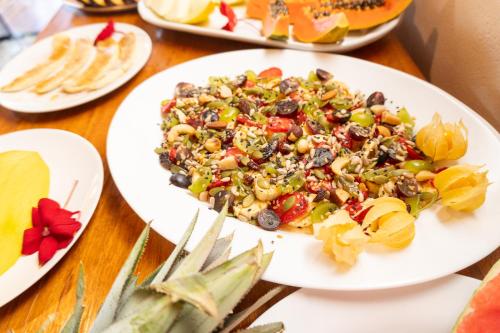 a plate of food on a table with a salad at Vila da Mata Chalés in Alto Paraíso de Goiás