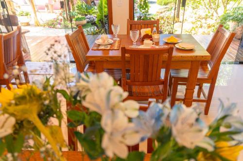 a wooden table and chairs with food on it at Vila da Mata Chalés in Alto Paraíso de Goiás