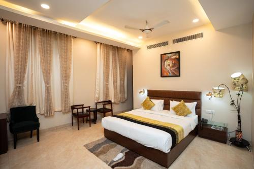 a hotel room with a bed and a table and chairs at Hotel Radiance Courtyard in Varanasi