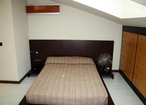 1 dormitorio con 1 cama grande y cabecero marrón en Sealand Apartment, en Les Cases d'Alcanar