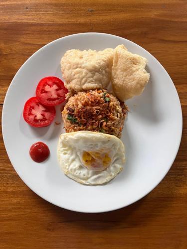 einen Teller mit einem Spiegelei und Tomaten in der Unterkunft Lime Penida Cottages in Nusa Penida