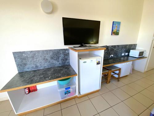 a kitchen with a tv on top of a counter at Osprey Holiday Village Unit 201 1 Bedroom in Exmouth