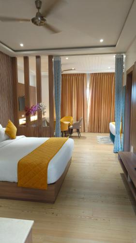 a bedroom with a large bed and a living room at Hotel Three Seasons in Vrindāvan