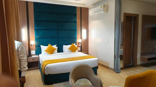 a bedroom with a large bed with a blue headboard at Hotel Three Seasons in Vrindāvan