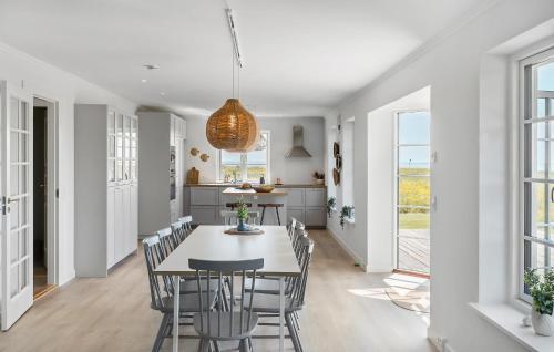 Askøにある4 Bedroom Amazing Home In Askøのテーブルと椅子のあるキッチンとダイニングルーム