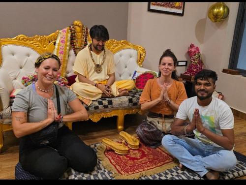 a group of people sitting in a living room doing yoga at Karma Hostel in Khajurāho