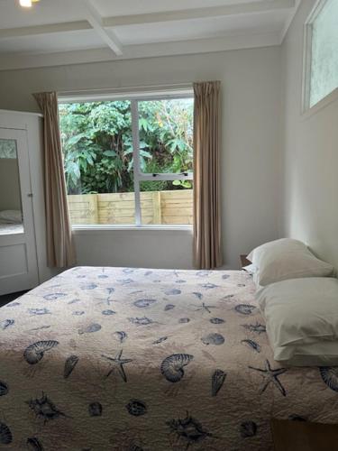 um quarto com uma cama e uma grande janela em 4 Parris St em New Plymouth